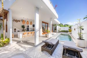 a white house with a swimming pool and a kitchen at Anatha Villa Uluwatu in Badung
