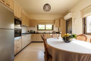 a kitchen with a table with chairs and a kitchen with at Villa Katrin in Ialysos