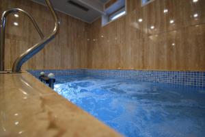 a large tub with blue water in a room at Simada Center Guesthouse in Varshets