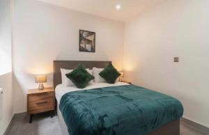 a bedroom with a bed with green sheets and pillows at Comfortable 1 Bed Apartment Town Centre in Preston