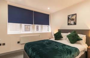 a bedroom with a large bed with green sheets and pillows at Comfortable 1 Bed Apartment Town Centre in Preston