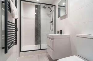 a white bathroom with a sink and a shower at Comfortable 1 Bed Apartment Town Centre in Preston