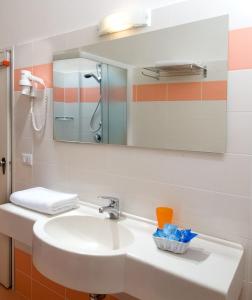 La salle de bains est pourvue d'un lavabo et d'un miroir. dans l'établissement Hotel Continental, à Milano Marittima