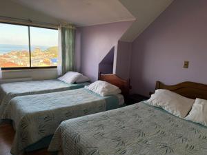 a hotel room with two beds and a window at Altos de Miramar in Puerto Montt