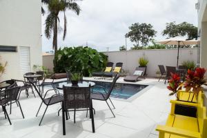 a patio with tables and chairs and a swimming pool at Hotel e Pousada VIVÁ in Chapada dos Guimarães