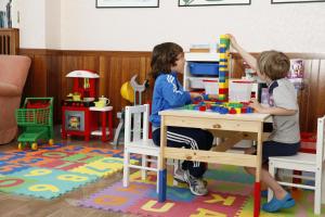 zwei Kinder, die mit Spielzeug in einem Zimmer spielen in der Unterkunft Hotel Continental in Milano Marittima