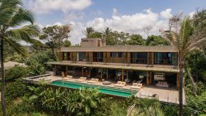 a house with a swimming pool in front of it at Barracuda Hotel & Villas in Itacaré