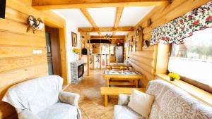a living room in a log cabin with chairs and a table at Willa POŚREDNIA - widok na Tatry z każdego pokoju in Zakopane
