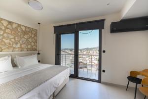 a bedroom with a bed and a view of a city at kallos of Skiathos in Skiathos