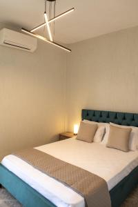 a bedroom with a large bed with a blue headboard at Oasis Resort Pure Relaxation Serenity in Agia Marina Mikrolimanou +65 photos