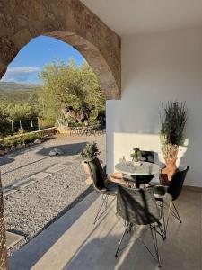 eine Terrasse mit Tisch und Stühlen und einem Torbogen in der Unterkunft Ckamares in Sikéa