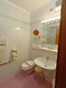 a white bathroom with a sink and a toilet at Life Hotels Rosalpina in Folgaria +42 photos