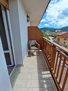 a chair sitting on a balcony with a view at Life Hotels Rosalpina in Folgaria