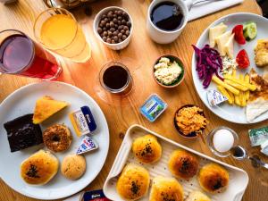 a wooden table with plates of food and glasses of wine at Ala Stone Hotel - Balloon View Experience in Göreme