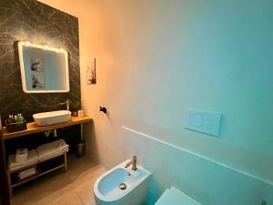 a bathroom with a blue toilet and a sink at DMC - Alloggio Turistico in Anzio