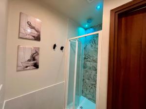 a bathroom with a shower and a toilet and pictures on the wall at DMC - Alloggio Turistico in Anzio +24 photos