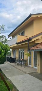 a house with two benches and a table on a patio at Camp Kalinovac in Zatonje
