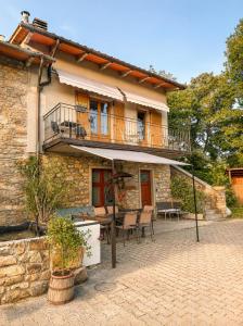 a house with a balcony and a table and chairs at Casa Campomonte 2 in Poppi Stazione
