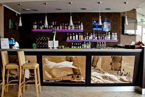 a bar with two chairs and a counter with bottles at Hotel Galion in Gdańsk