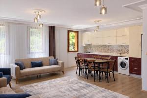 a kitchen and living room with a table and chairs at İmera Suite Otel in Uzungöl