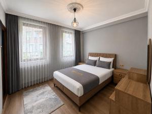a bedroom with a large bed and two windows at İmera Suite Otel in Uzungöl