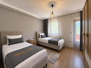 a hotel room with two beds and two windows at İmera Suite Otel in Uzungöl