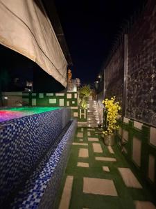 a building with a pool at night with flowers at Hilton Suites Lahore in Lahore