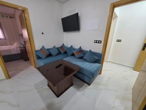 a living room with a blue couch and a tv at Le calme d'ajdir in Ajdir