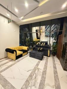 a living room with a yellow couch and a table at Hilton Suites Lahore in Lahore