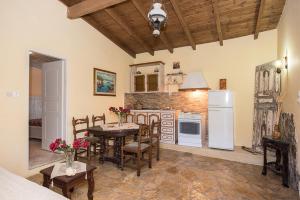 a kitchen with a table and chairs and a refrigerator at Villa Argo, Feakia in Agios Gordios