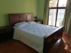 a bedroom with a large bed with a window at Hotel & Resort Casa Bella in El Hawaii
