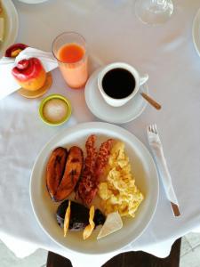 a plate of breakfast food and a cup of coffee at Hotel & Resort Casa Bella in El Hawaii +6 photos