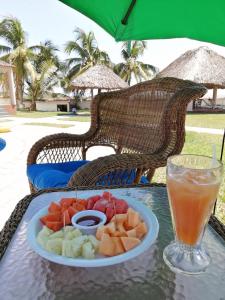 a plate of fruit on a table with a drink at Hotel & Resort Casa Bella in El Hawaii