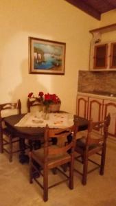stół jadalny i krzesła z wazonem kwiatów na nim w obiekcie Villa Argo, Feakia w mieście Agios Gordios
