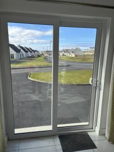 a sliding glass door with a view of a street at Beach House in Donegal