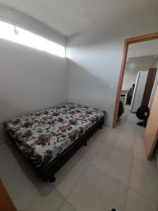 a small bedroom with a bed in a room at Kitnet Perequê in Matinhos