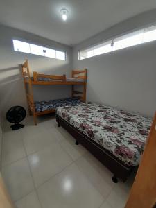 a bedroom with a bed and two bunk beds at Kitnet Perequê in Matinhos