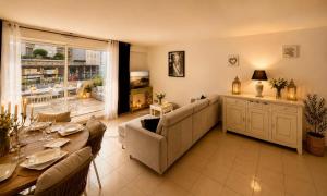 a living room with a couch and a table at Le Aix Rotonde Mirabeau - Centre Ville Terrasse Garage in Aix-en-Provence