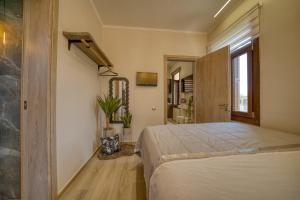 a bedroom with a large bed and a bathroom at Lotza apartment Votsalo in Vrontádos