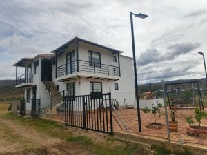 a white house with a fence in front of it at El Eden in Sáchica
