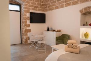 a room with a bed and a table and a tv at SuiteLab in Palo del Colle