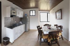 a kitchen with a wooden table and a table and chairs at El Eden in Sáchica