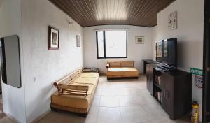 a living room with couches and a flat screen tv at El Eden in Sáchica
