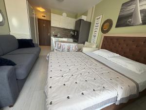a bedroom with a large bed and a couch at ADMIRAL PLASA studiyo-25C in Sunny Beach +25 photos