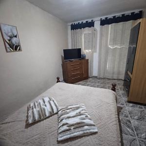 a bedroom with a bed with towels on it at Casa Singela in Miguel Pereira