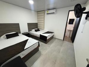 a room with two beds and a sink in it at Hotel Logistico in Santa Marta