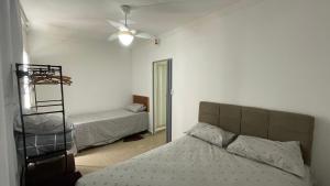 a bedroom with two beds and a ceiling fan at Meu Lar Fora de Casa in Jandira