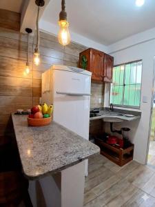 a kitchen with a bowl of fruit on a counter at Estúdio moderno com cozinha america in Ilhéus