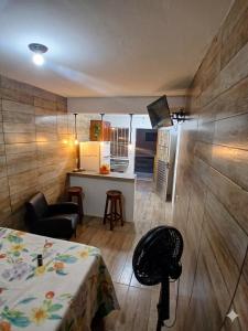 a room with a bed and a kitchen with a table at Estúdio moderno com cozinha america in Ilhéus