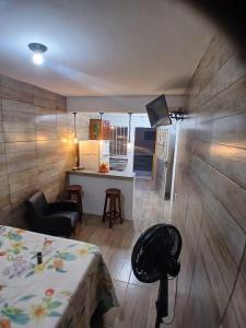a room with a bed and a kitchen with a table at Estúdio moderno com cozinha america in Ilhéus +9 photos